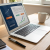 A split-screen image showing a laptop with a LinkedIn ad dashboard on one side and a gold‑styled bar graph indicating ROI on the other, against a dark navy background.